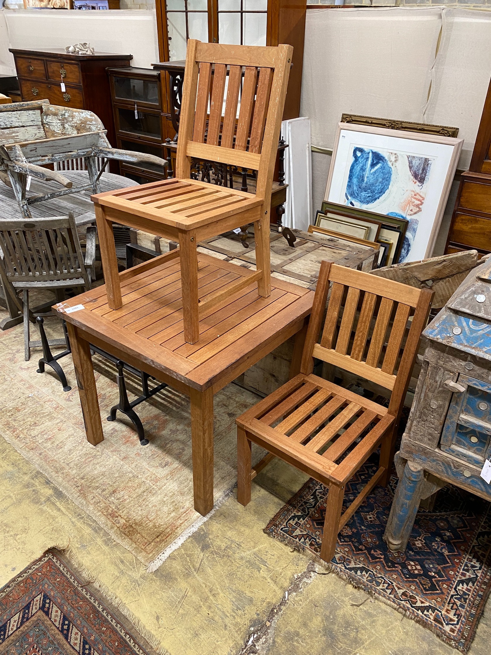 A square teak garden table, width 80cm, height 73cm and two teak garden chairs